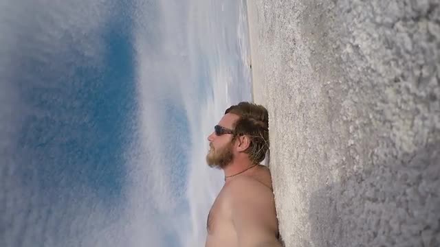 Man in Sunglasses Lies on the Surface of the Dried Salt Lake. Salar de Uyuni, Bolivia