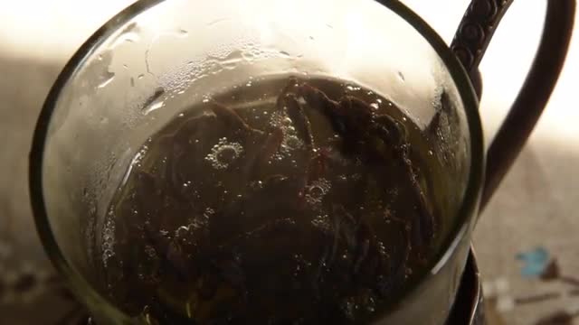 Putting Tea Leaves in a Glass, Brewing Tea in a Cup. Close up