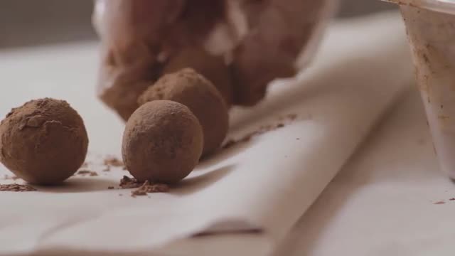 Woman Puts Confectioner Chocolate Balls on a Parchment Paper. Candy Factory.