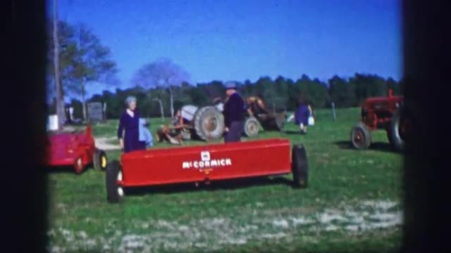 1961: couple inspect farming equipment at a yard sale at rural home IOWA