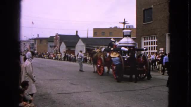1963: crowd gathered on the side of the street to watch a horse drawn cart BARRINGTON, ILLINOIS