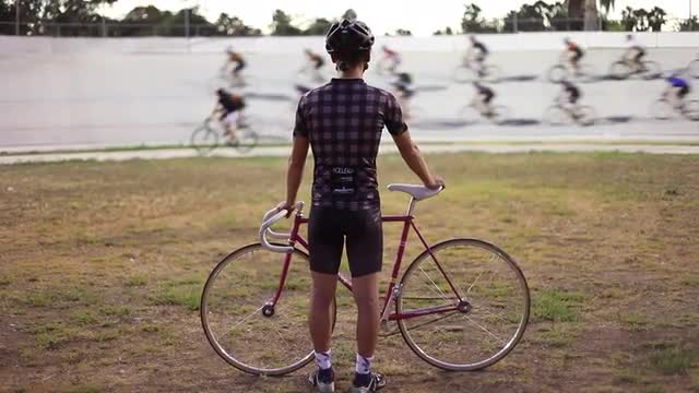 A bicyclist stands off...