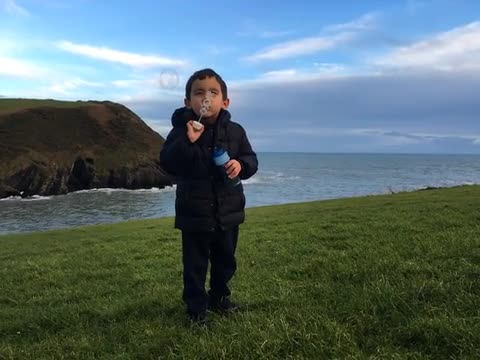 Child blowing bubbles on Atlantic Irish coast