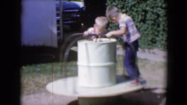 1958: in the cylindrical drum both the kids are enjoying especially the boy kneels down while rotati