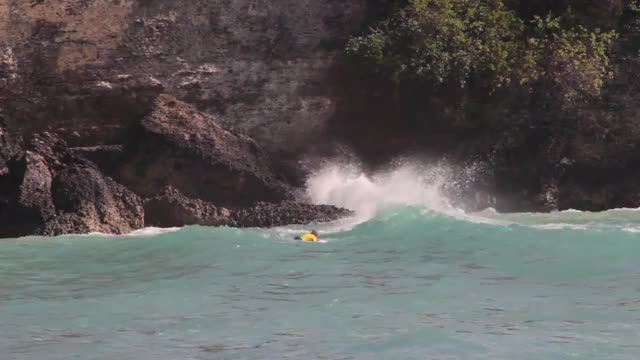 Man Paddles on a Surfboard