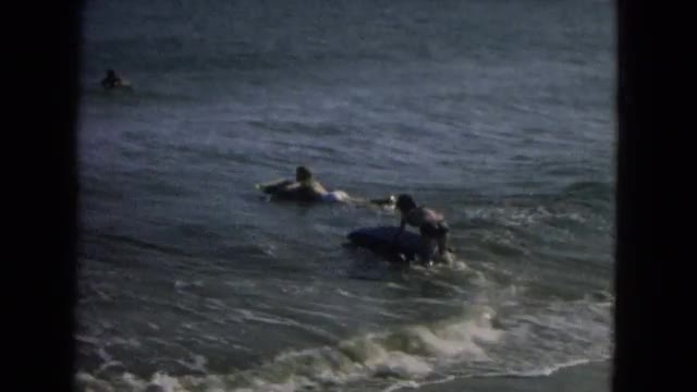 1967: boy on beach watching others in ocean on rafts NEVADA
