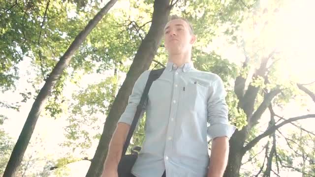 Young happy attractive IT man walking through the park