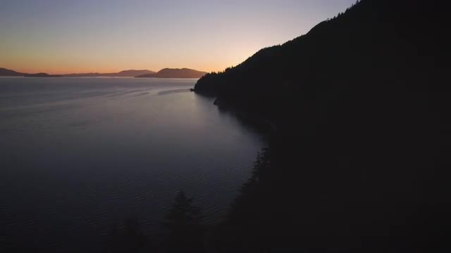 Aerial Dolly from Tree Shadows to Orange and Blue Sunset on Ocean Islands
