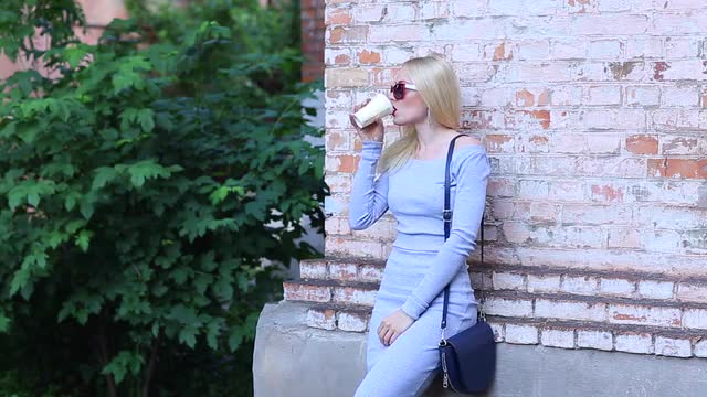 Female Waiting Drinks Coffee Stand Near Wall