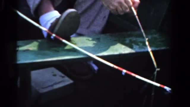 1958: lively older gentleman catching fish boat fishing on a bright sunny day MINNESOTA