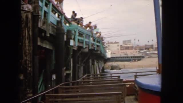 1963: a large group of men fishing together at the pier on the edge of a body of water. CALIFORNIA