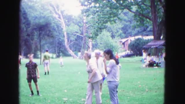 1971: middle-aged woman and older woman take turns throwing large darts in park OMAHA, NEBRASKA