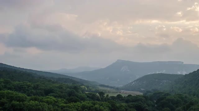 Misty Evening In Mountains With Moving Clouds And Sun Shining