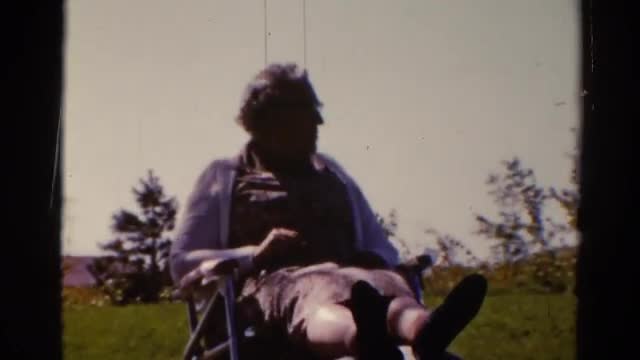 1962: an elderly woman sits in a lawn chair in a grassy area on a chilly day CATSKILL, NEW YORK