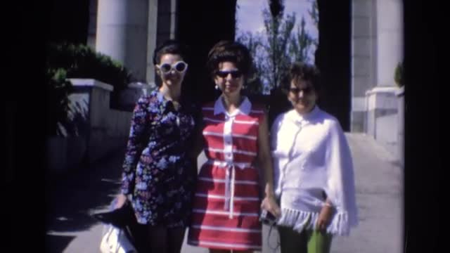 1969: three women with sunglasses standing in front of a large structure SPAIN