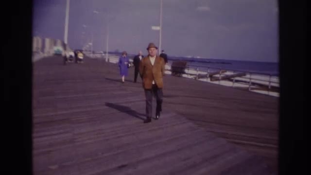 1967: a man walking next to the beach while smoking with his hands behind his back ROCKAWAY BEACH NE