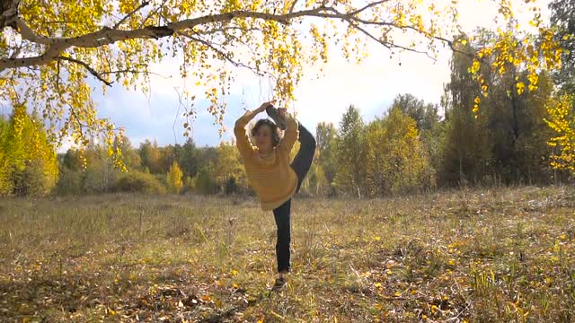 Slow Motion Girl Acrobatics Background Leaf Fall. Sunny Day.