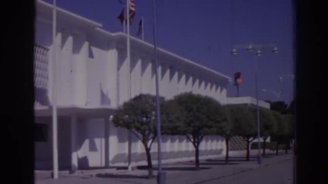 1962: the american and turkish flags in front of a large building IZMIR TURKEY