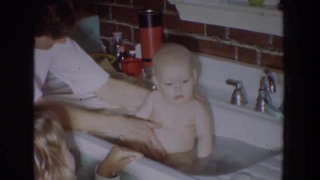 1965: little baby getting a bath in the kitchen sink. FALLSTON MARYLAND