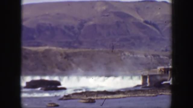 1938: water flowing in from large waterfalls and dams into a large body of water. CALIFORNIA