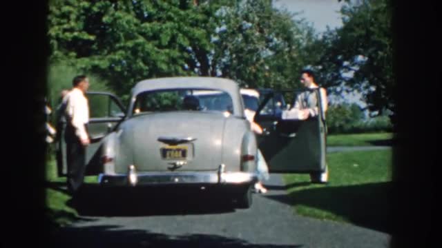 1959: gentleman exits car while another gentleman opens door for lady NEBRASKA