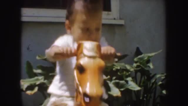 1952: toddler plays on old-fashioned rocking horse CALIFORNIA