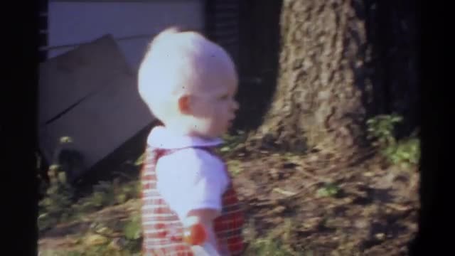 1974: baby playing in pathway of garden FLORIDA