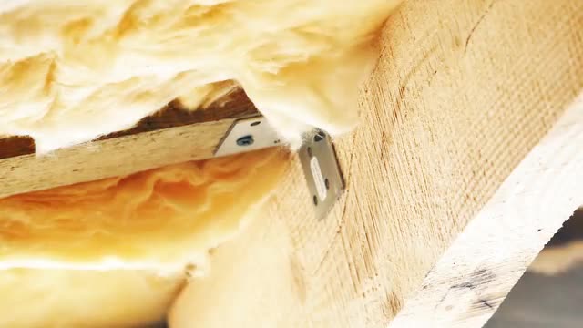 Man Insulating the Roof With Fiberglass