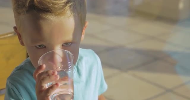 Boy eating chocolate donut and drinking water
