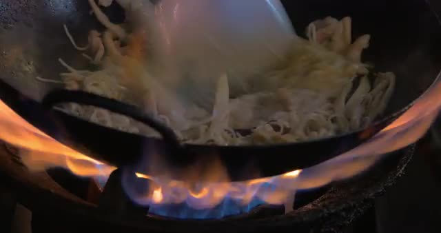 Making noodles dish in wok on gas fire, Thailand