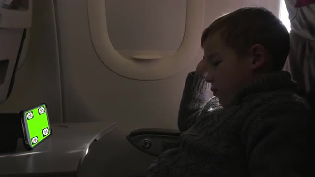 Child watching something on smartphone in the airplane. Chroma Key