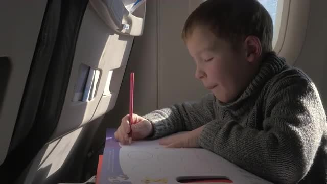 Child drawing during the flight
