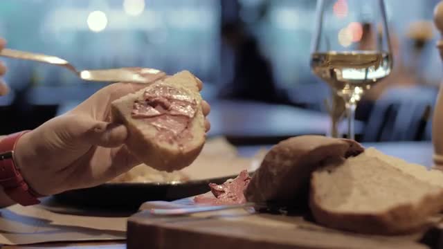 Woman eating bread with meat paste in the cafe