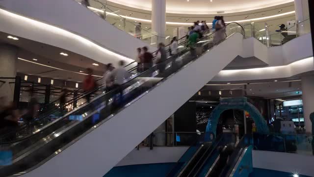 Timelapse of people on escalators in trade centre