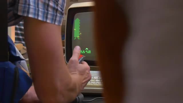 Instructor Teaches Kids to Play Old Computer Game by Joystick Black and Green Screen Games Contest P