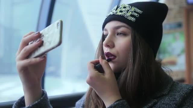 Girl lipstick looking at the phone