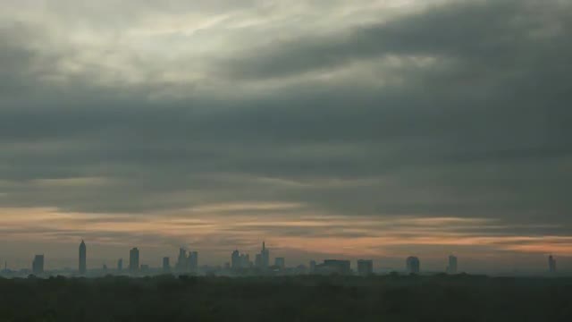Timelapse of sun rising in overcast sky over the city