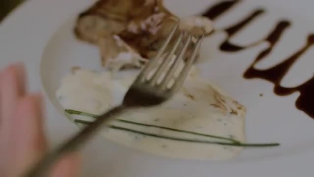 Woman eating meat roll in restaurant