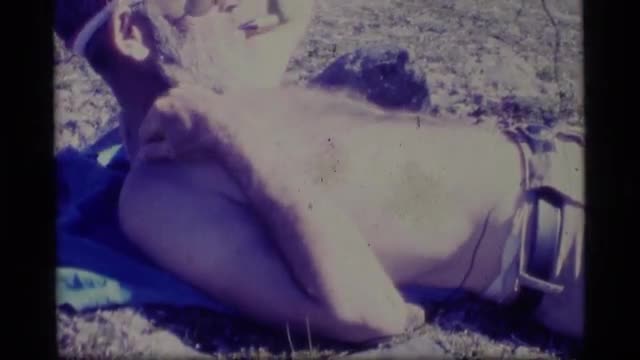 1977: a older gentleman relaxing with a pipe and watching the catch of the day come in from sea. ALA
