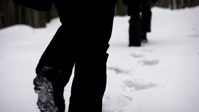 Legs in Winter Boots Making a Pass Through Thick Snow. Close up on Shoes. Steadicam Shot. Walking in