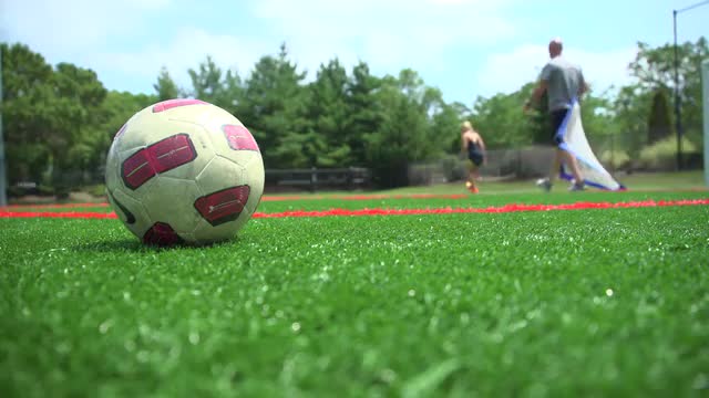 Soccer athlete stretching near a ball