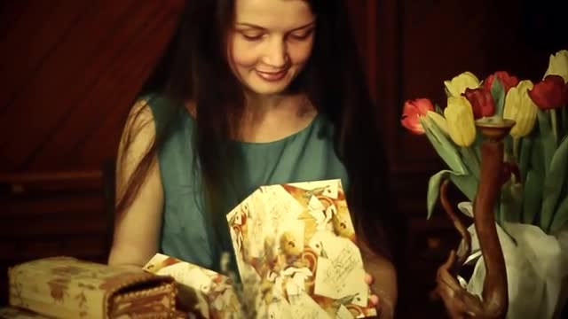 Good Looking Female With Long Brunette Hair in a Blue Dress is Smelling a Bunch of Flowers, Opening 