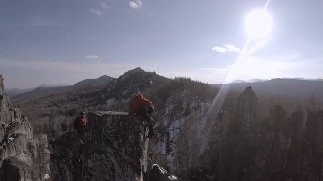 Two Climbers on a Cliff Top. Sunny Winter Day Backlight