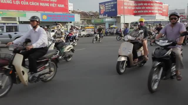 REAR POV WS Motorcycle Traffic Along Busy Street / Ho Chi Minh, Vietnam
