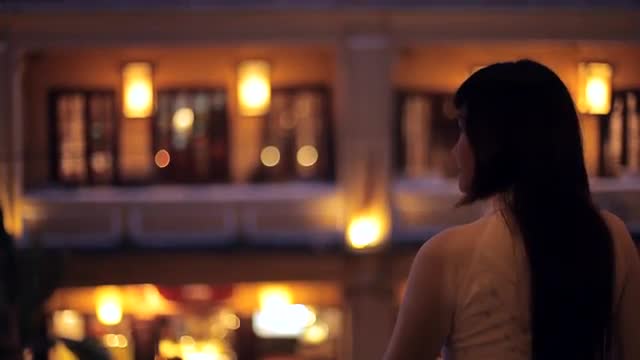 MH TU Woman with Long Hair Looking at Illuminated Buildings at Night / Hoi An, Vietnam
