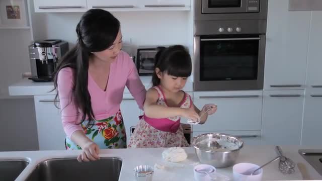 MS Mother and daughter cooking together in kitchen / China