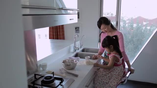 MS PAN Mother and daughter making food together in the kitchen / China