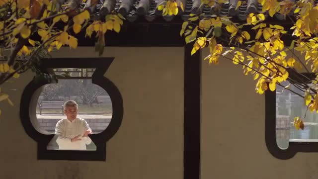 MS View through gazebo's window of mature man doing Tai Chi / Beijing, China