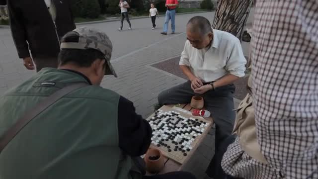 MS PAN Men playing traditional board game on bench in park / Beijing, China