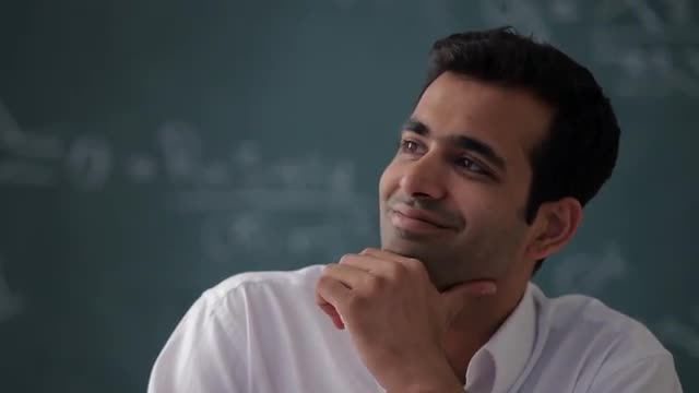 MS TU Man looking up from desk and smiling